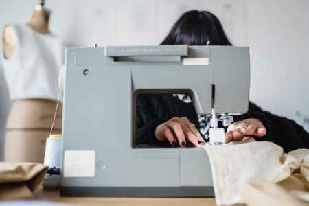 seamstress sewing on machine in atelier