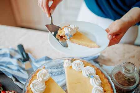 anonymous woman with pie on plate near table in kitchen